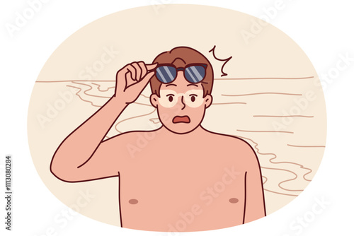 Tanned man takes off sunglasses and screams after getting sunburn relaxing on beach. Funny guy tanned during trip to resort and needs cream to protect against sun rays and ultraviolet radiation