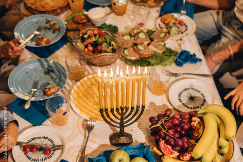 Festive Hanukkah table with traditional food and family at it. photo