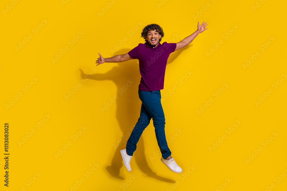Full body photo of attractive young man jump excited run dressed stylish violet clothes isolated on yellow color background Full body photo of attractive young man jump excited run dressed stylish violet clothes isolated on yellow color background