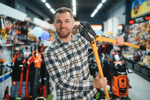 A male buyer in a modern hardware store. A large selection of tools and various household and construction goods