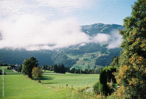 Landscape of green field, mountains and clouds photo