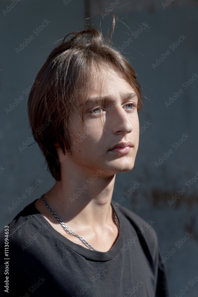 © Basil Pind/Stocksy - Close-up portrait of a young man in sunlight