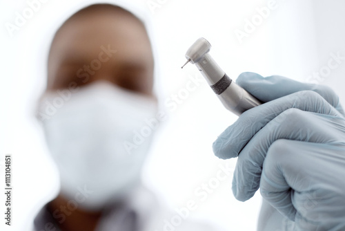 Closeup Shot Of Black Dentist Doctor In Medical Mask Holding Dental Drill In Hand, Ready For Making Dental Treatment, African Stomatologist Using Sterile Professional Equipment, Selective Focus photo