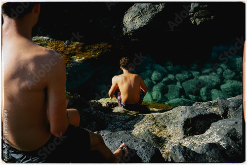 Young friends relaxing seated on the ocean shore in the Canary Islands photo