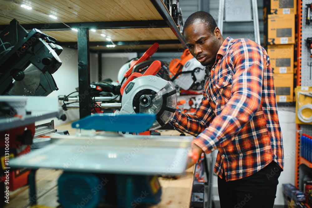African american male buyer chooses a toolbox in a hardware store. A large selection of tools African american male buyer chooses a toolbox in a hardware store. A large selection of tools