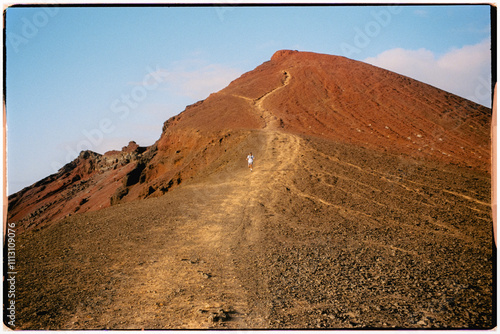 Analog panorama of a hiking professional running down a volcano photo