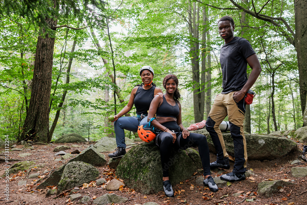 Group of friends taking a break during hiking trip in forest Group of friends taking a break during hiking trip in forest