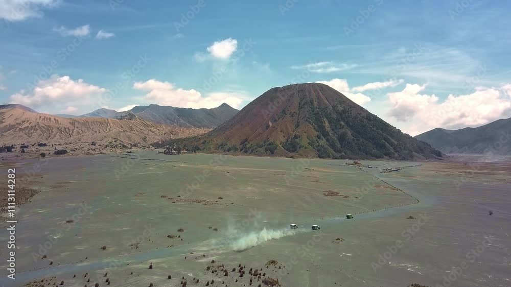 Aerial view of Mount Bromo in Indonesia, showcasing its majestic peak and surrounding volcanic landscape. The clouds add a dramatic touch to the scenery, highlighting the power of nature. Aerial view of Mount Bromo in Indonesia, showcasing its majestic peak and surrounding volcanic landscape. The clouds add a dramatic touch to the scenery, highlighting the power of nature.