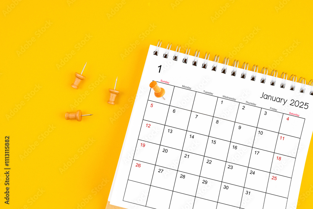 January 2025 Monthly desk calendar for 2025 year with wooden pin on yellow background. January 2025 Monthly desk calendar for 2025 year with wooden pin on yellow background.