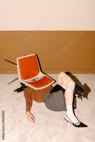 Surreal Artistic Scene with Person Under Chair photo