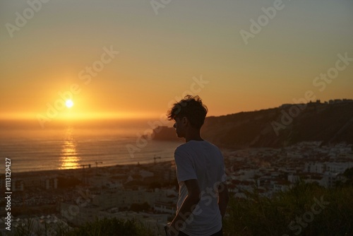 Young man watches Portugese sunset photo