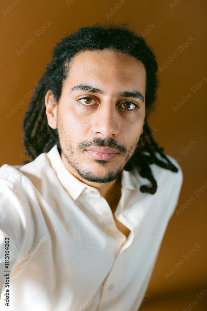 Studio portrait of modern man looking at camera over brown background Studio portrait of modern man looking at camera over brown background