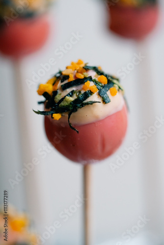 Close-up of a marinated egg with colorful toppings on a stick photo