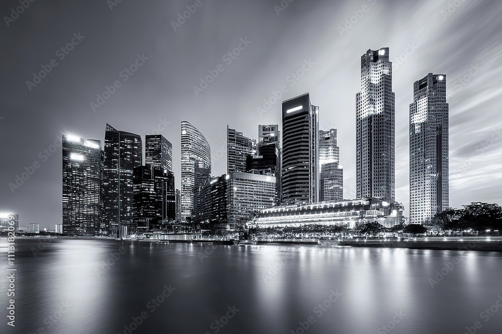 Fototapeta premium City skyline illuminated at night with modern skyscrapers along the waterfront