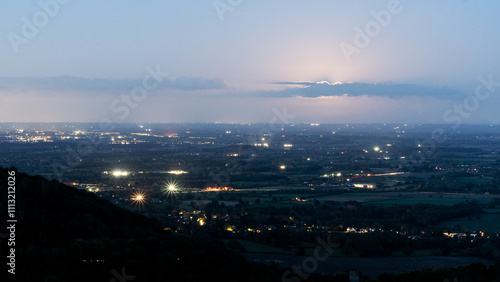 High on a hill above a landscape of farmland and villages at night photo