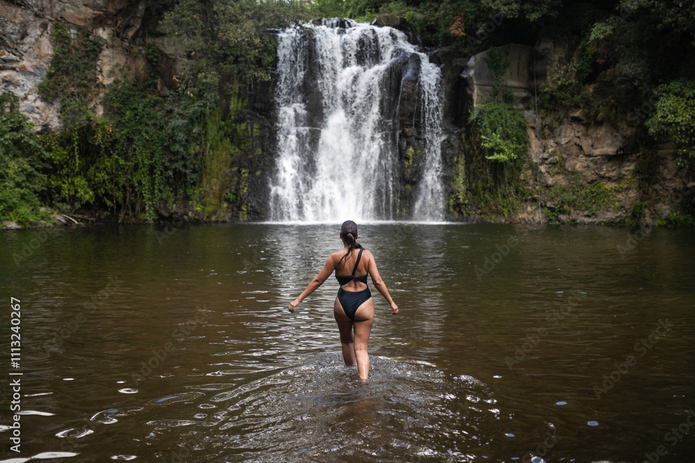 woman bathing in a waterfall in nature