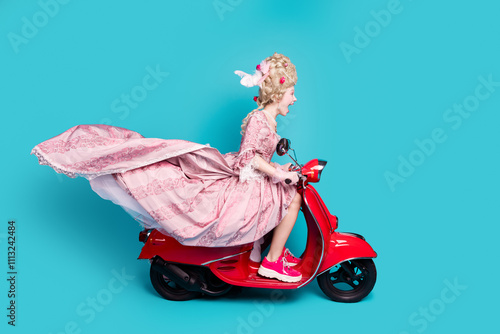 Photo of positive charming lady princess driving fast moped scooter isolated on blue color background photo