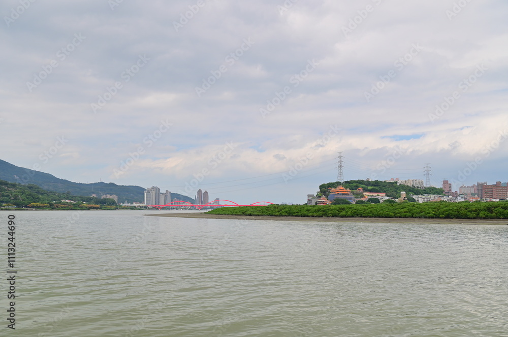 From Shezidao Taitou Park, a cloudy day reveals the elegant Guandu Bridge with the majestic Guanyinshan beyond, offering a tranquil riverside panorama. From Shezidao Taitou Park, a cloudy day reveals the elegant Guandu Bridge with the majestic Guanyinshan beyond, offering a tranquil riverside panorama.