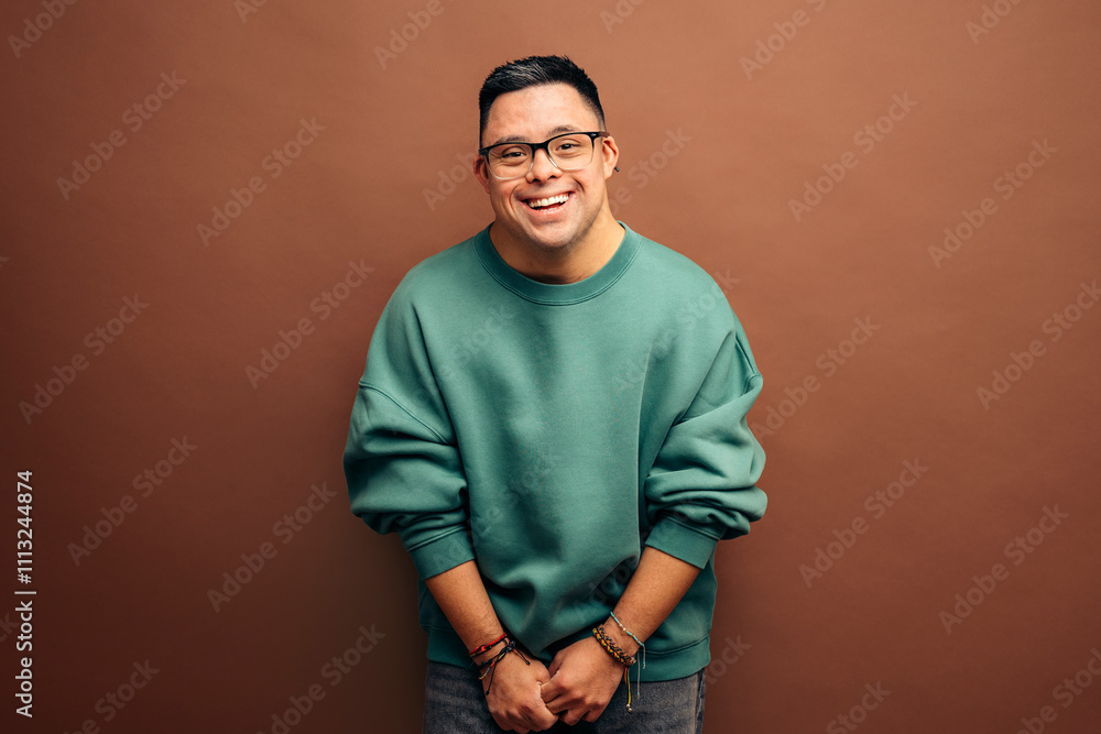 Smiling man with Down syndrome wearing green sweatshirt Smiling man with Down syndrome wearing green sweatshirt