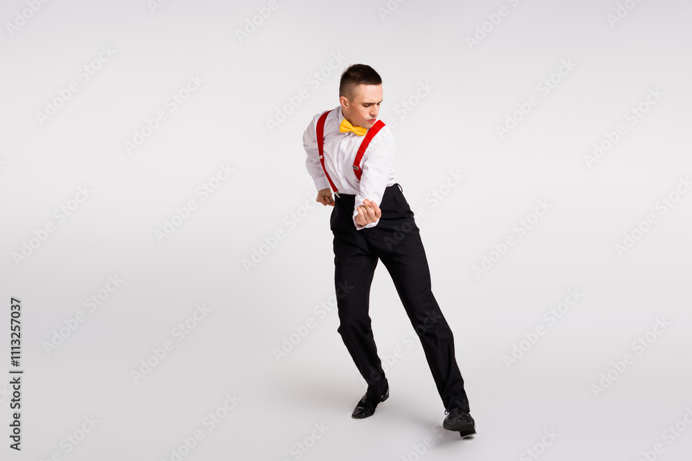 Dynamic young man in elegant attire performing energetic dance on white background Dynamic young man in elegant attire performing energetic dance on white background