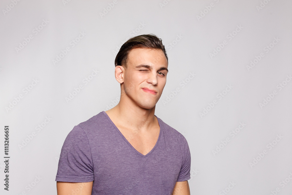 Handsome young man on grey background looking at camera Handsome young man on grey background looking at camera