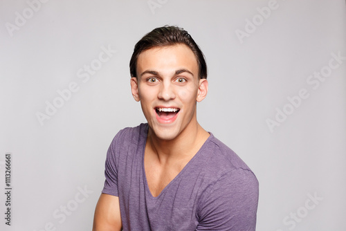 Handsome young man on grey background looking at camera photo