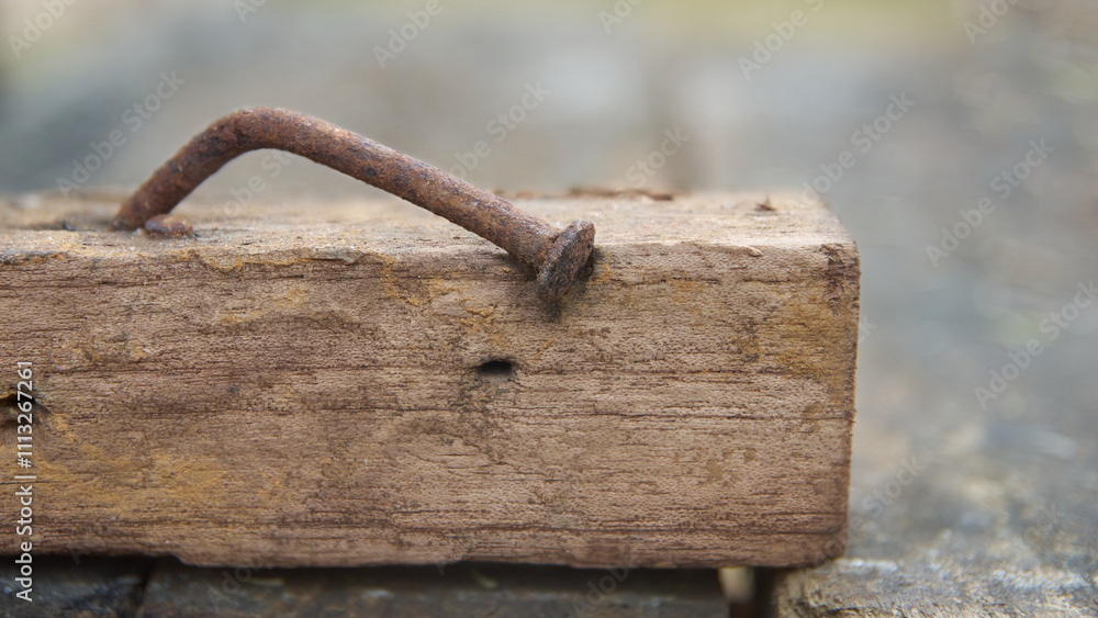 rusty nail in a piece of weathered wood in close-up view, nail is bent at an angle soft focus with blurry background and copy space rusty nail in a piece of weathered wood in close-up view, nail is bent at an angle soft focus with blurry background and copy space