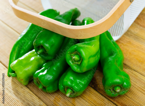 Fresh green sweet Anaheim peppers on wooden kitchen countertop photo