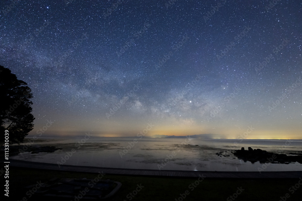 海面に星が映る能登半島の海岸と天の川