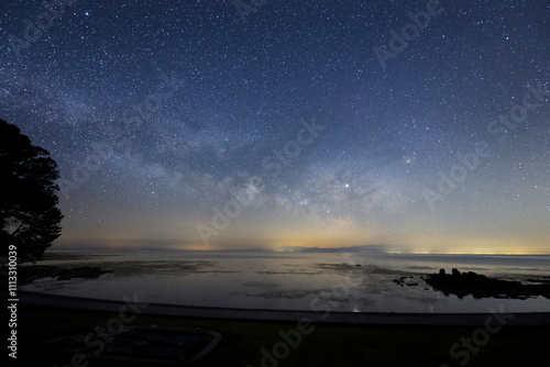Obraz na płótnie 海面に星が映る能登半島の海岸と天の川 w salonie