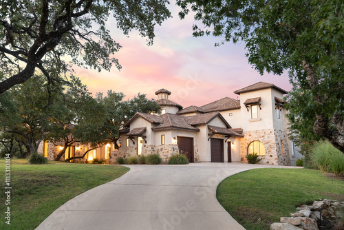 Quadro su tela Elegant home nestled among trees during a vibrant sunset