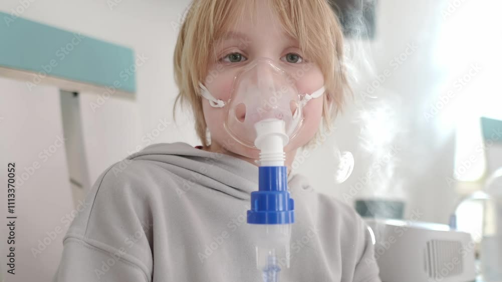Preteen boy inhalation therapy by the mask of inhaler. Close up video of a kid with respiratory problem or asthma. Sick boy with clear oxygen mask. Preteen boy inhalation therapy by the mask of inhaler. Close up video of a kid with respiratory problem or asthma. Sick boy with clear oxygen mask.