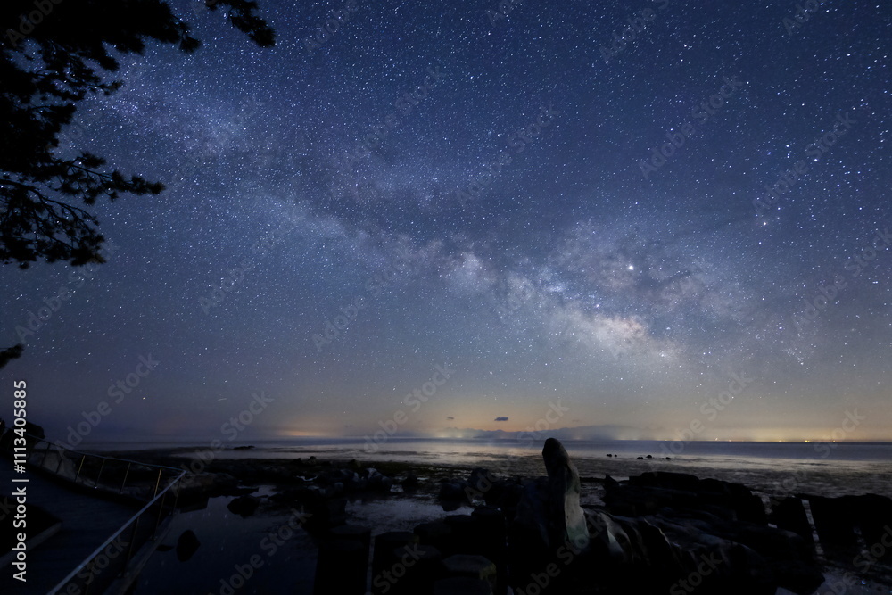 海岸沿いのオブジェと天の川と能登半島の星空