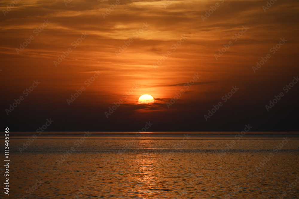 Stunning Sunset over Calm Ocean Waters with Vibrant Orange Sky Stunning Sunset over Calm Ocean Waters with Vibrant Orange Sky