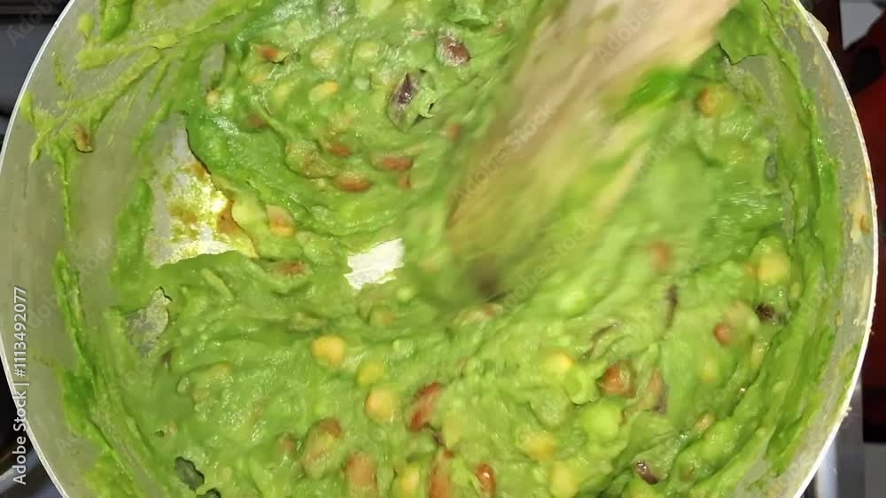 Chef stirring a vibrant green pea puree in a pot with a wooden spoon, creating a smooth and creamy texture for a delicious dish Chef stirring a vibrant green pea puree in a pot with a wooden spoon, creating a smooth and creamy texture for a delicious dish