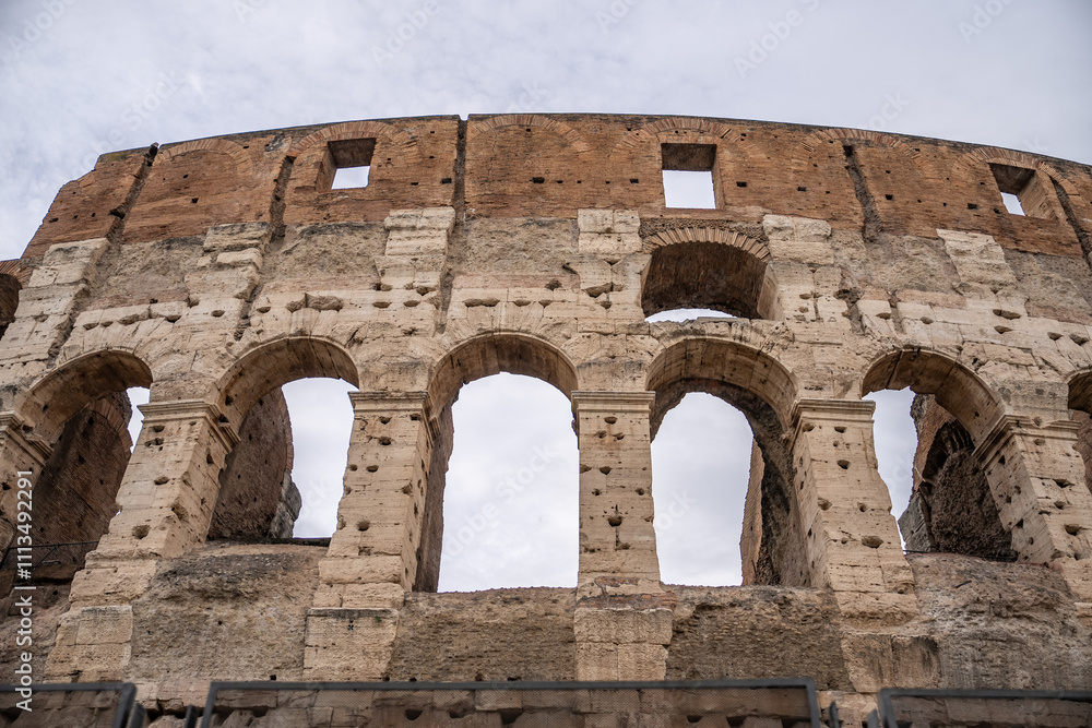 Obraz premium Arches archictecture of Colosseum (Colosseo) exterior with clouds and sky. Rome, Italy.