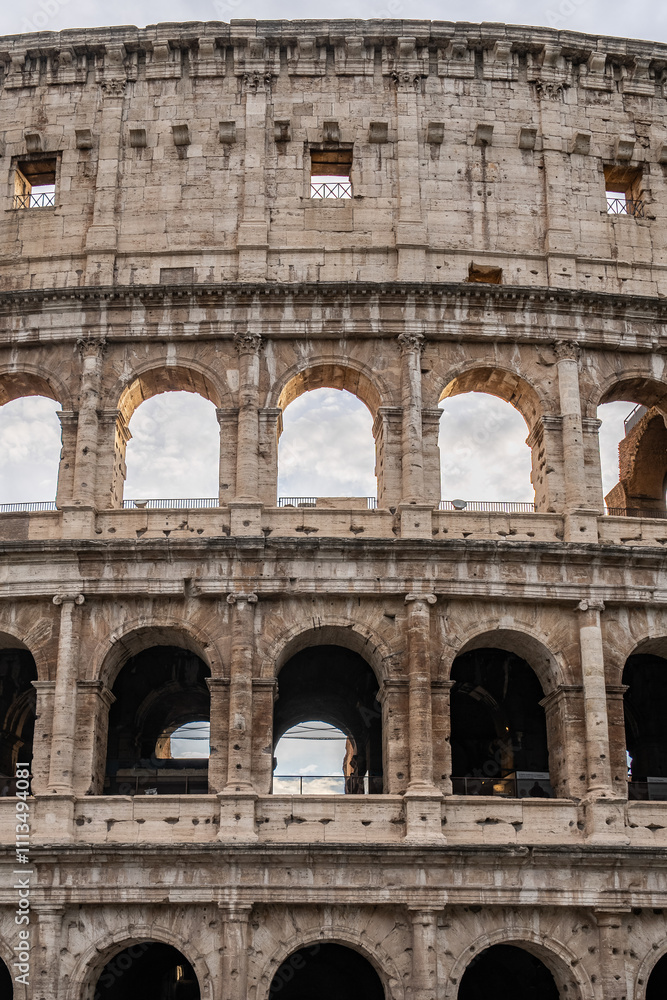 Obraz premium Arches archictecture of Colosseum (Colosseo) exterior with clouds and sky. Rome, Italy.
