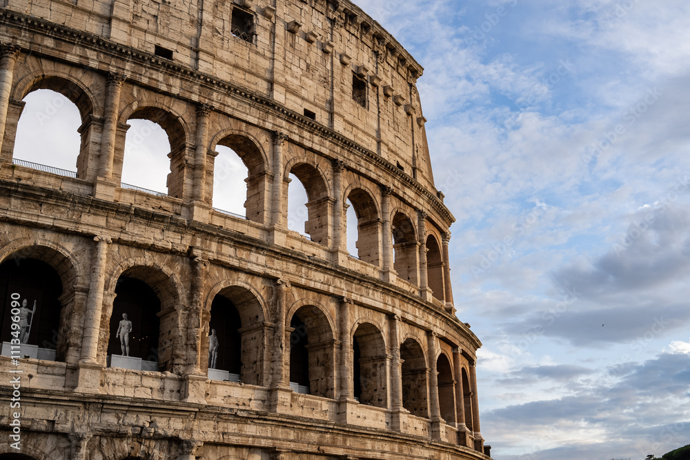 Fototapeta premium Arches archictecture of Colosseum (Colosseo) exterior with clouds and sky. Rome, Italy.