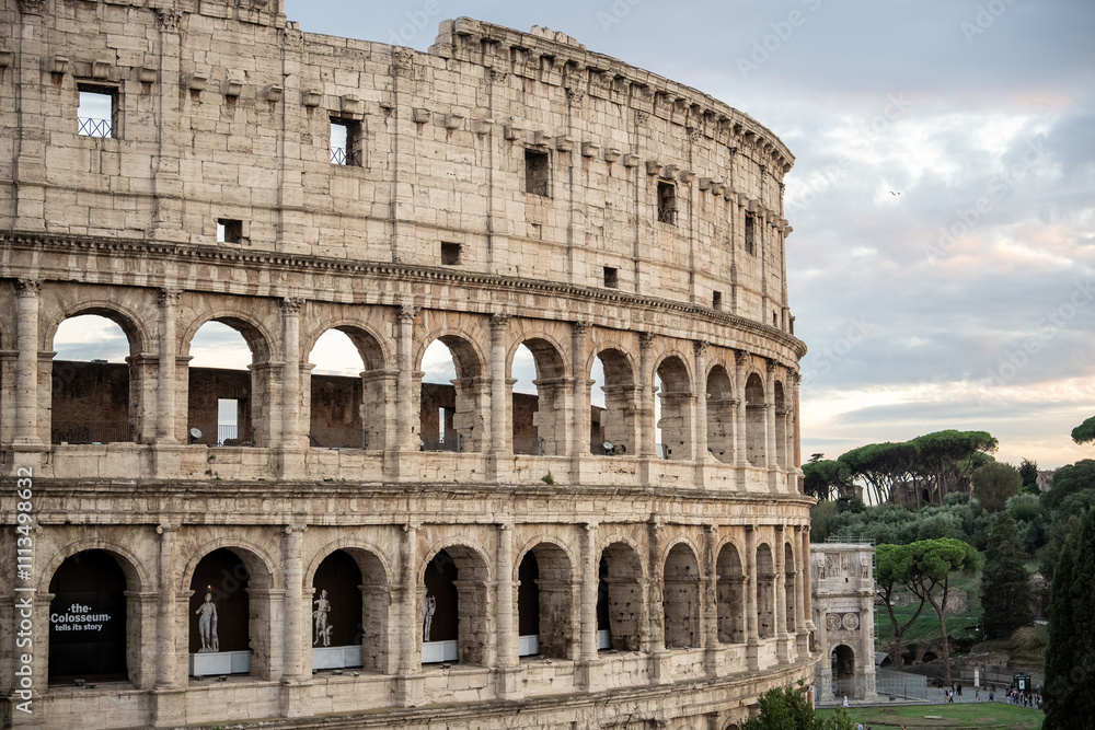 Fototapeta premium Arches archictecture of Colosseum (Colosseo) exterior with clouds and sky. Rome, Italy.