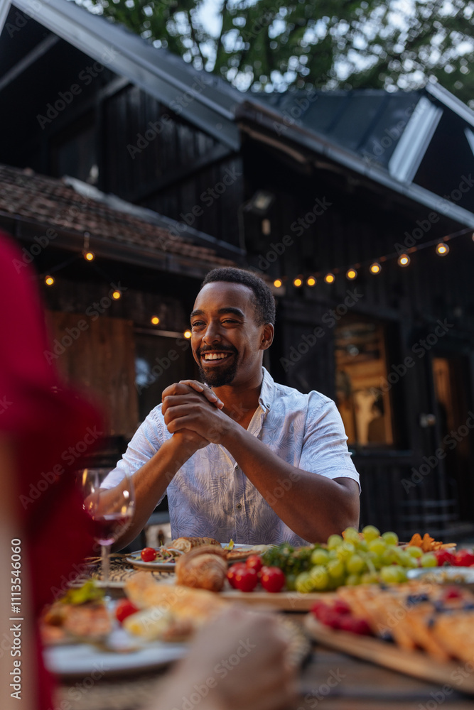 Man looking pleased at a dinner outdoors Man looking pleased at a dinner outdoors