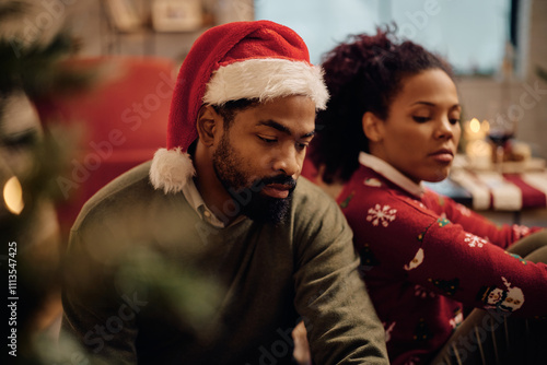 Disappointed black man arguing with his wife on Christmas.