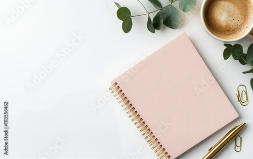 Stylish workspace with a pink notebook coffee cup and greenery on a clean desk