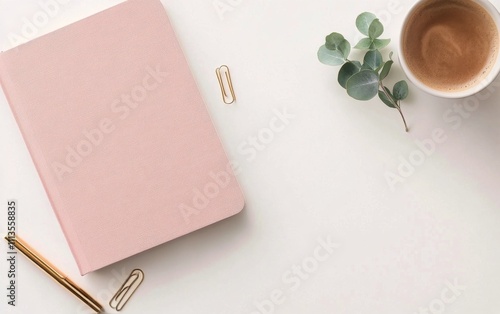 Stylish workspace with a pink notebook coffee cup and greenery on a clean desk