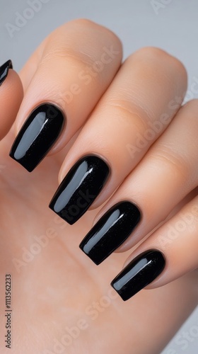 Elegant black nail polish on well manicured hand showcasing stylish design an...