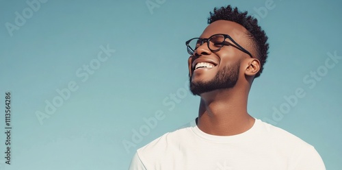 Young man smiles brightly against a colorful background in a casual setting