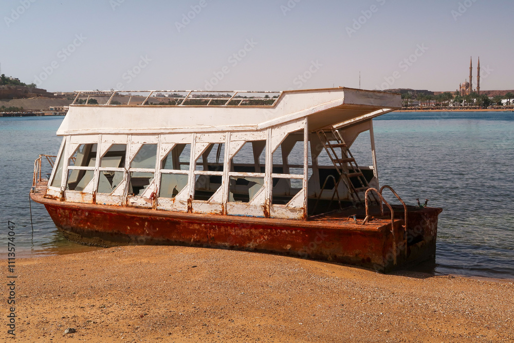 A boat is sitting on the beach with a rusty exterior A boat is sitting on the beach with a rusty exterior