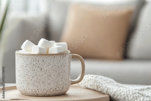 Marshmallows in a decorative glass bowl with flowers on a marble surface