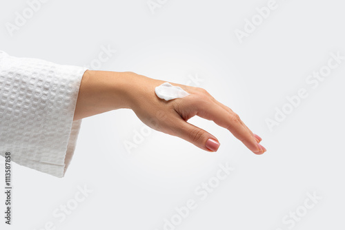 A white smear of body smoothing cream on woman's hand