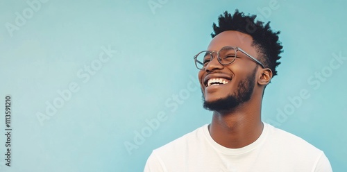 Young man smiles brightly against a colorful background in a casual setting
