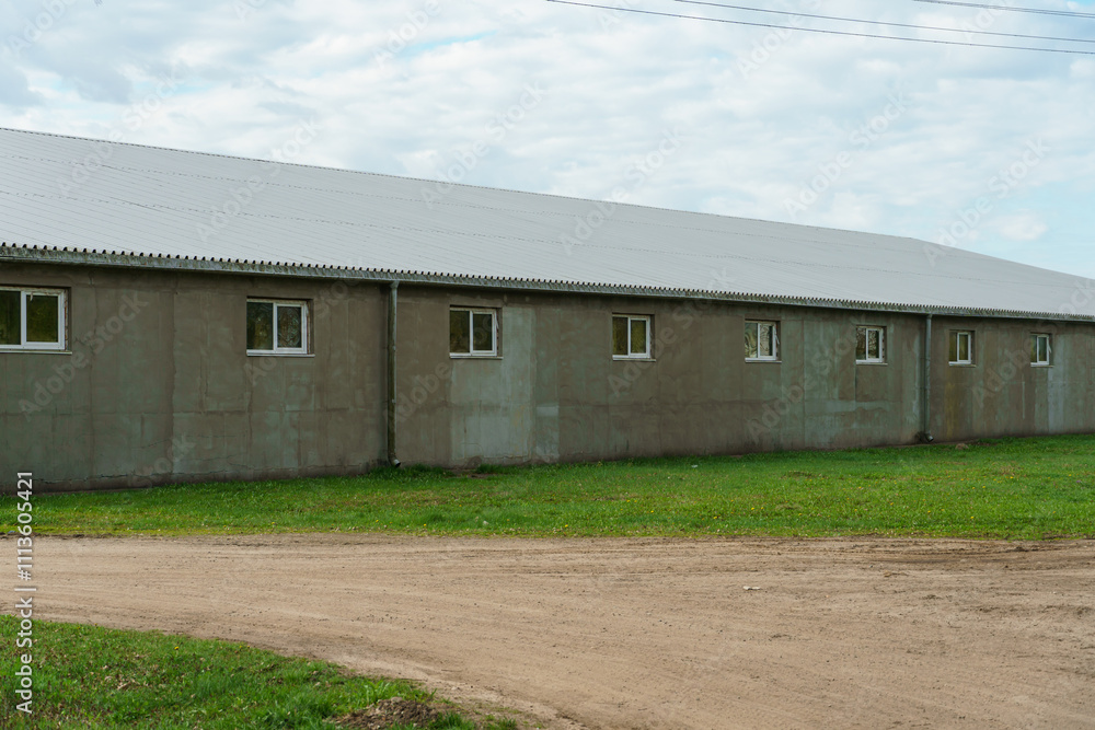 An industrial warehouse on the territory of an agricultural complex. Commercial warehouse building, cargo workshop, logistics center. An industrial warehouse on the territory of an agricultural complex. Commercial warehouse building, cargo workshop, logistics center.